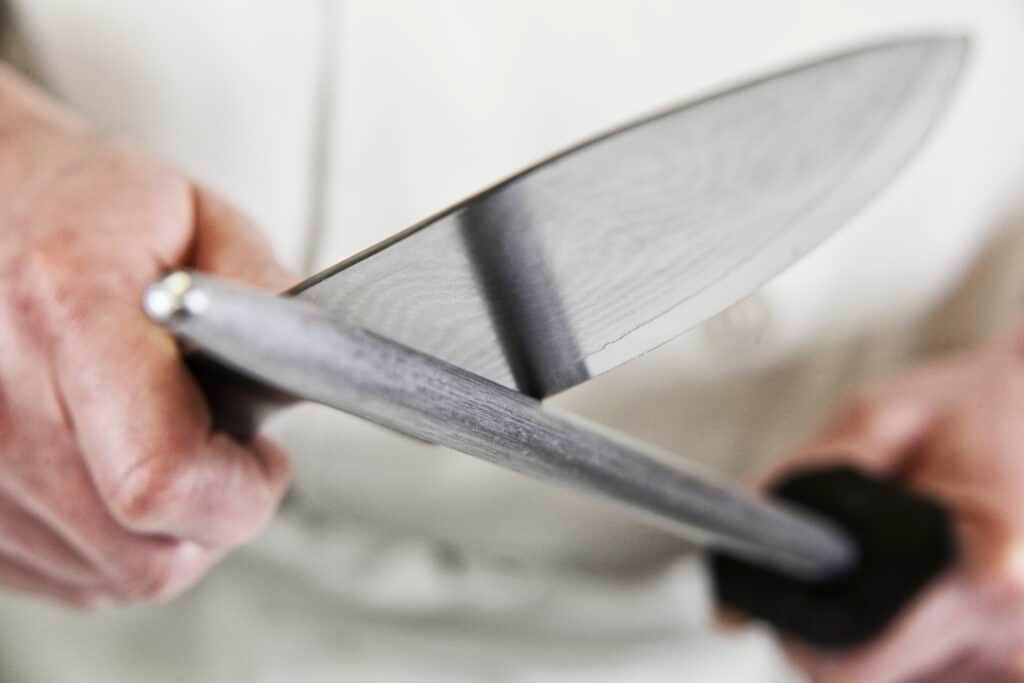 close up of a chef sharpening a large kitchen knif 2022 03 04 02 07 54 utc