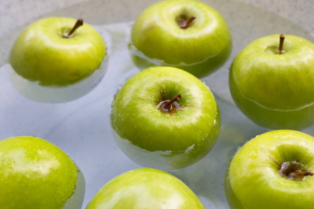 Soak green apples in water. Washing fruit concept
